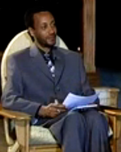 An Eritrean journalist is sitting in front of the despotic president-for-life of Eritrea looking scared to death