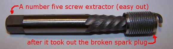 A number five screw extractor (easy out)still attached to the broken piece of the spark plug after I took it out